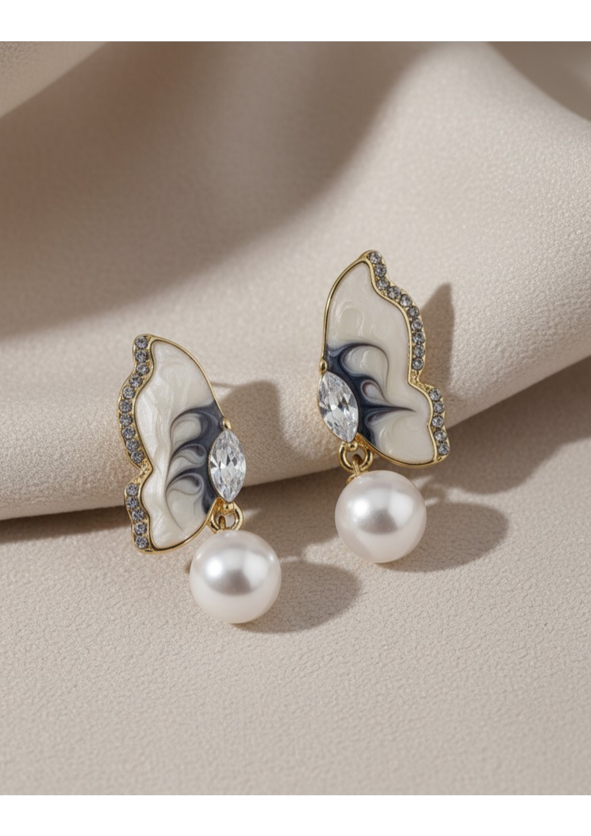 Butterfly-inspired pearl drop earrings.